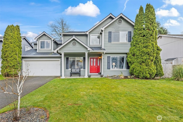 traditional-style house with a front yard, fence, driveway, an attached garage, and a shingled roof