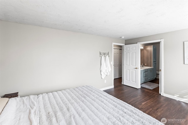 unfurnished bedroom featuring dark wood-type flooring, baseboards, and connected bathroom