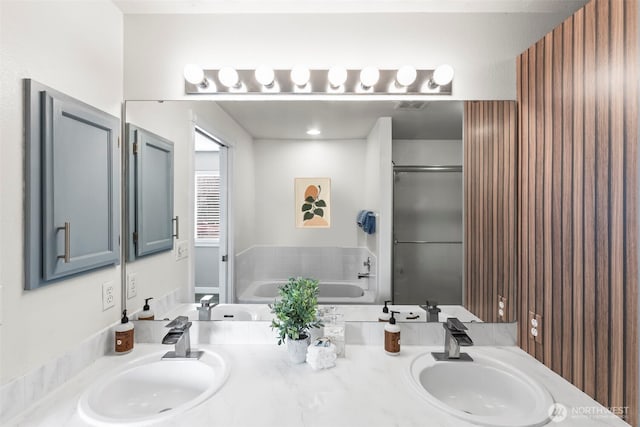 full bath with a garden tub, double vanity, and a sink