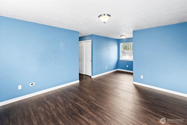 unfurnished room with baseboards and wood finished floors