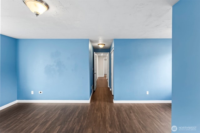 unfurnished room with baseboards and wood finished floors