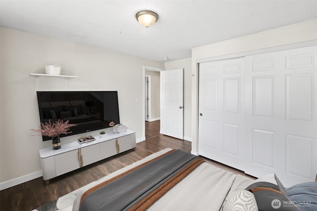 bedroom with a closet, baseboards, and wood finished floors