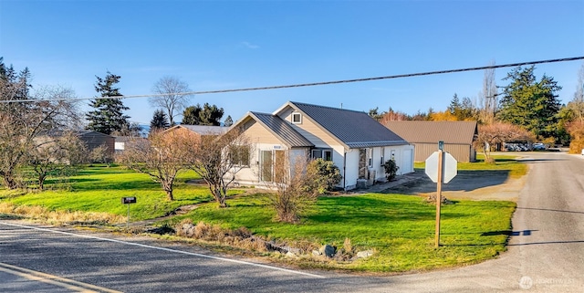 view of front of house with metal roof and a front lawn