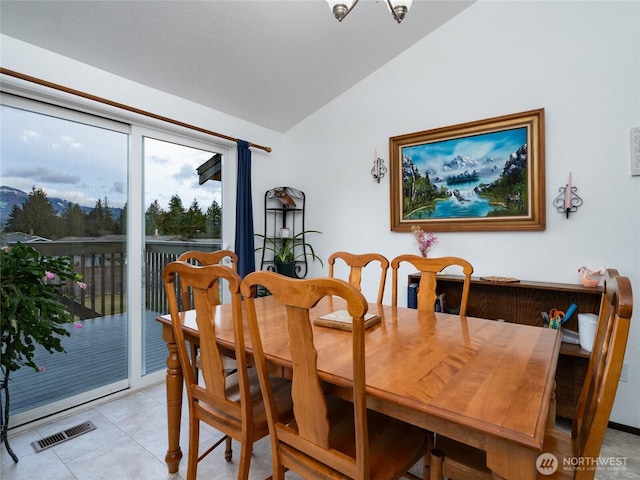 dining room with lofted ceiling, light tile patterned floors, and visible vents