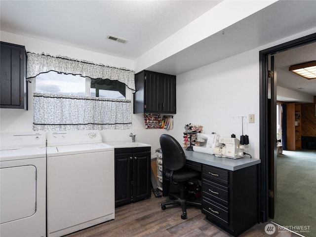 office with a sink, dark wood finished floors, washing machine and dryer, and visible vents