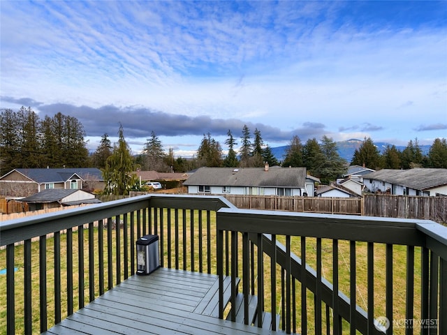 wooden deck with a residential view, a fenced backyard, and a lawn