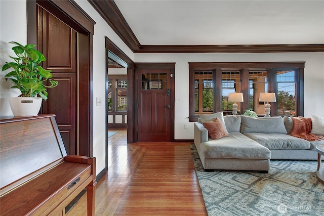 living room with light wood-style flooring, baseboards, and crown molding