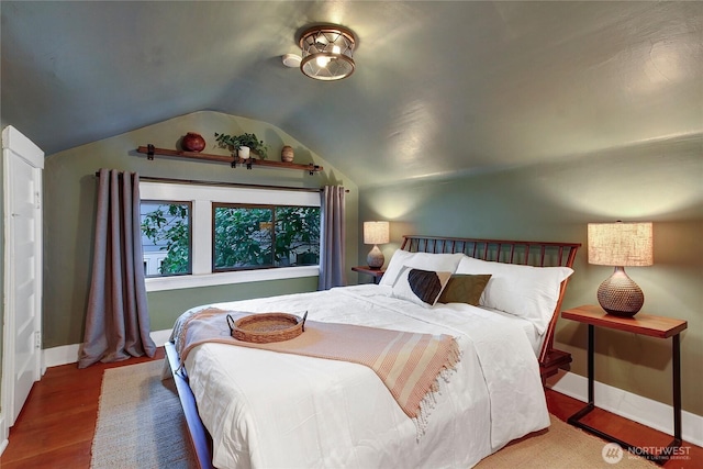 bedroom with baseboards, vaulted ceiling, and wood finished floors