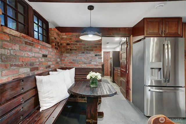 dining space featuring brick wall