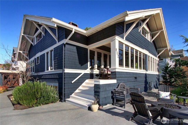 view of property exterior featuring a patio area and a fire pit