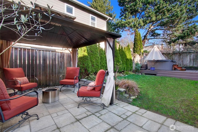 view of patio / terrace with a gazebo, fence, and a hot tub