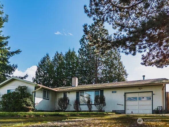 ranch-style house featuring a chimney and an attached garage