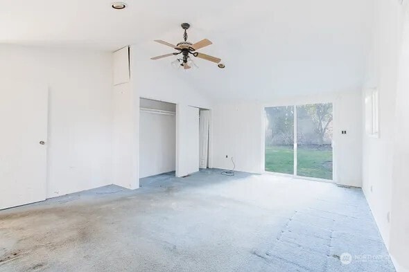 unfurnished bedroom with access to exterior, vaulted ceiling, and a ceiling fan