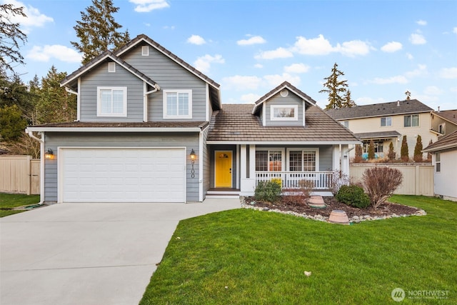 traditional-style home with covered porch, a garage, fence, driveway, and a front yard