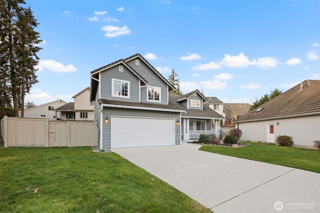 traditional-style house with a front yard, driveway, an attached garage, and fence