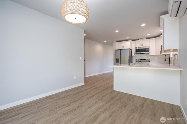 6490 Watson Loop, Maple Falls, WA 98266 - kitchen with light countertops, light wood-style flooring, baseboards, and appliances with stainless steel finishes
