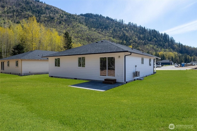 6490 Watson Loop, Maple Falls, WA 98266 - back of property featuring central AC, a patio area, a wooded view, a lawn, and a mountain view