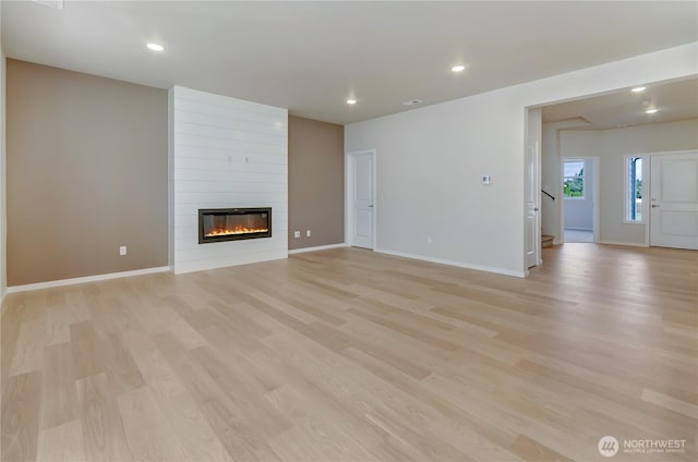 3467 183rd Street Ct E, Tacoma, WA 98446 - unfurnished living room featuring recessed lighting, a fireplace, baseboards, stairway, and light wood finished floors