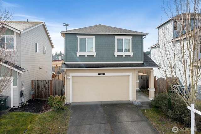 traditional-style house with a garage, fence, concrete driveway, and roof with shingles