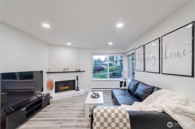 living room with a premium fireplace, wood finished floors, and recessed lighting