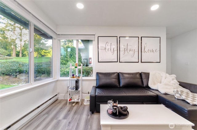 interior space with light wood-style floors, a baseboard heating unit, and recessed lighting