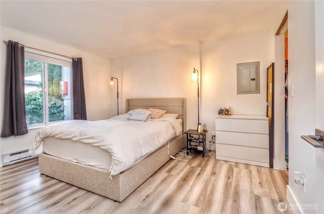 bedroom featuring baseboard heating, light wood-type flooring, and electric panel