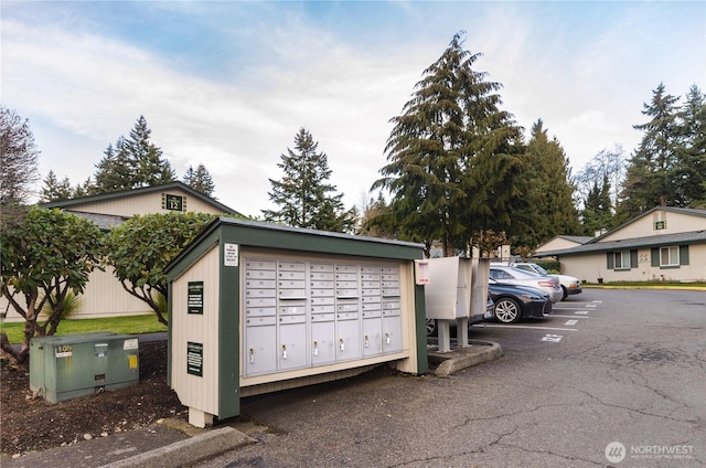 view of property's community with uncovered parking and mail area