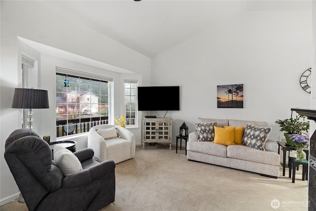 carpeted living area featuring baseboards and high vaulted ceiling