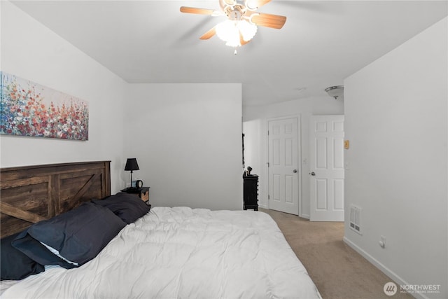 bedroom with a ceiling fan, light colored carpet, visible vents, and baseboards