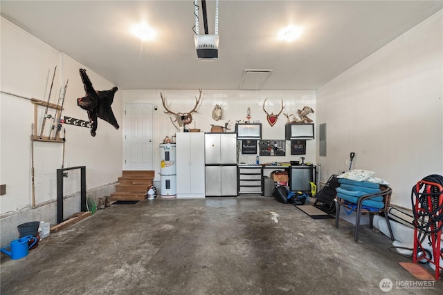 garage featuring a garage door opener, strapped water heater, and electric panel