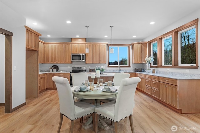 kitchen featuring light countertops, light wood-type flooring, a center island, and stainless steel microwave