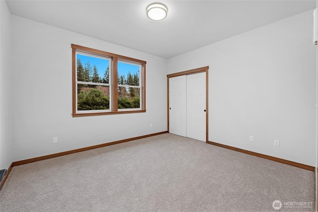 carpeted empty room featuring baseboards