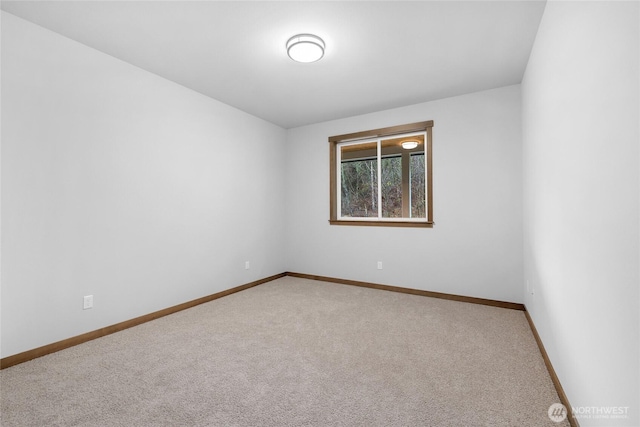 empty room featuring carpet and baseboards