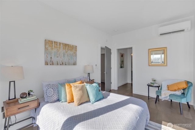 bedroom featuring a wall mounted air conditioner, wood finished floors, and baseboards