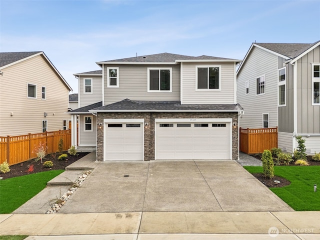 view of front of house with stone siding, concrete driveway, an attached garage, and fence