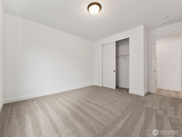 unfurnished bedroom featuring carpet, a closet, and baseboards