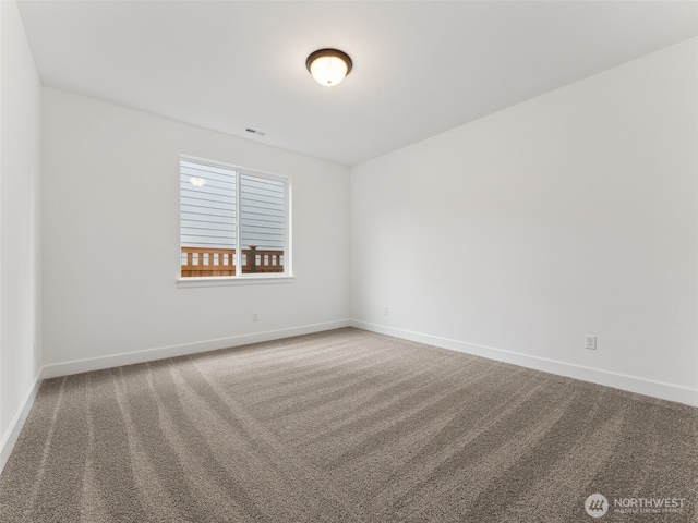 empty room featuring carpet flooring, visible vents, and baseboards