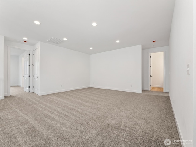 spare room featuring recessed lighting, light colored carpet, visible vents, and baseboards