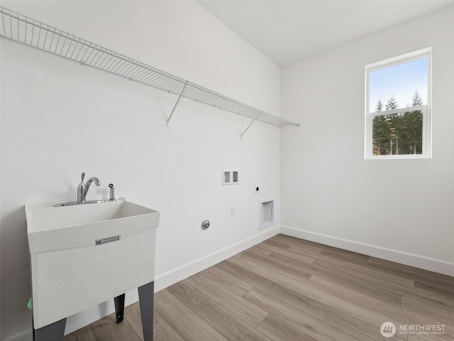 laundry area with laundry area, light wood finished floors, baseboards, hookup for a washing machine, and electric dryer hookup