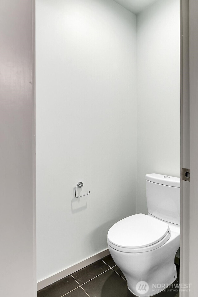 bathroom with toilet, tile patterned flooring, and baseboards