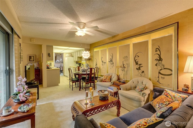 living area with a ceiling fan, light carpet, and a textured ceiling