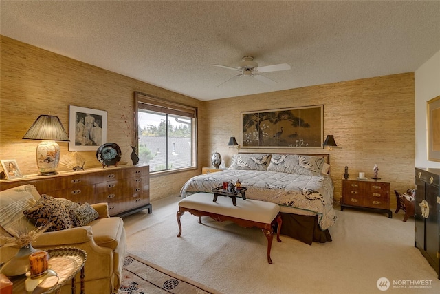 bedroom featuring light carpet, ceiling fan, and a textured ceiling