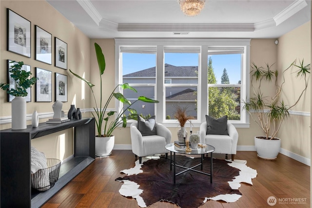 living area featuring a tray ceiling, wood-type flooring, a healthy amount of sunlight, and crown molding