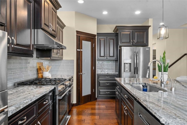 kitchen featuring dark wood-style floors, appliances with stainless steel finishes, a sink, and light stone countertops