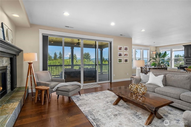 living area featuring dark wood-style floors, a fireplace, baseboards, and recessed lighting