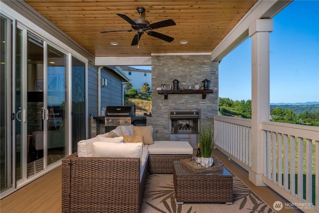 deck with an outdoor living space with a fireplace, ceiling fan, and area for grilling