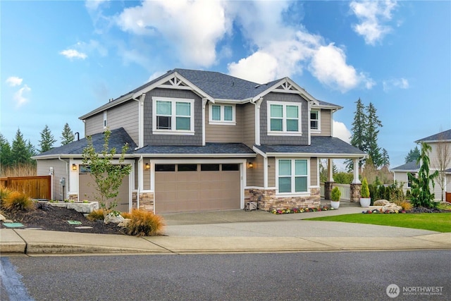 craftsman house featuring an attached garage, fence, stone siding, driveway, and roof with shingles