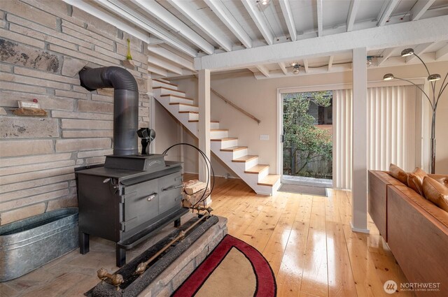 interior space featuring a wood stove, stairway, and hardwood / wood-style floors