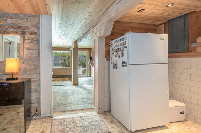 kitchen featuring wood ceiling and freestanding refrigerator