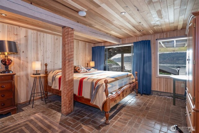 bedroom with wooden ceiling, brick floor, and wooden walls